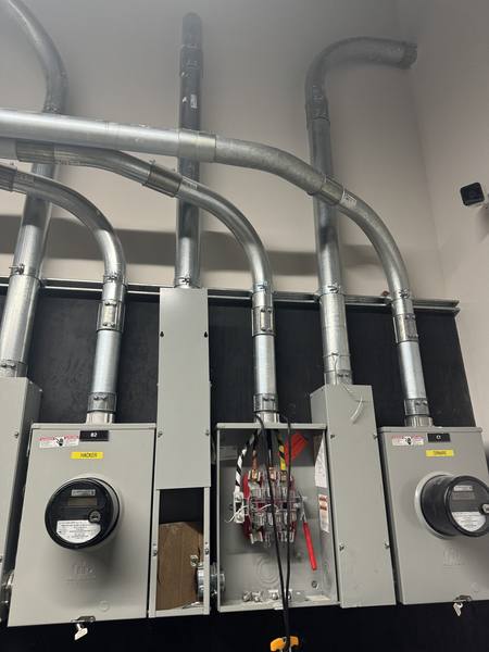 Multiple meter and disconnect panels being installed